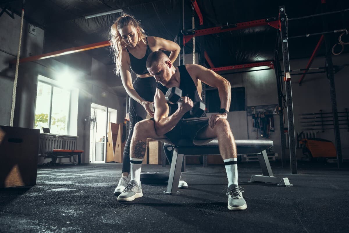 A trainer coaching a client through a strength workout