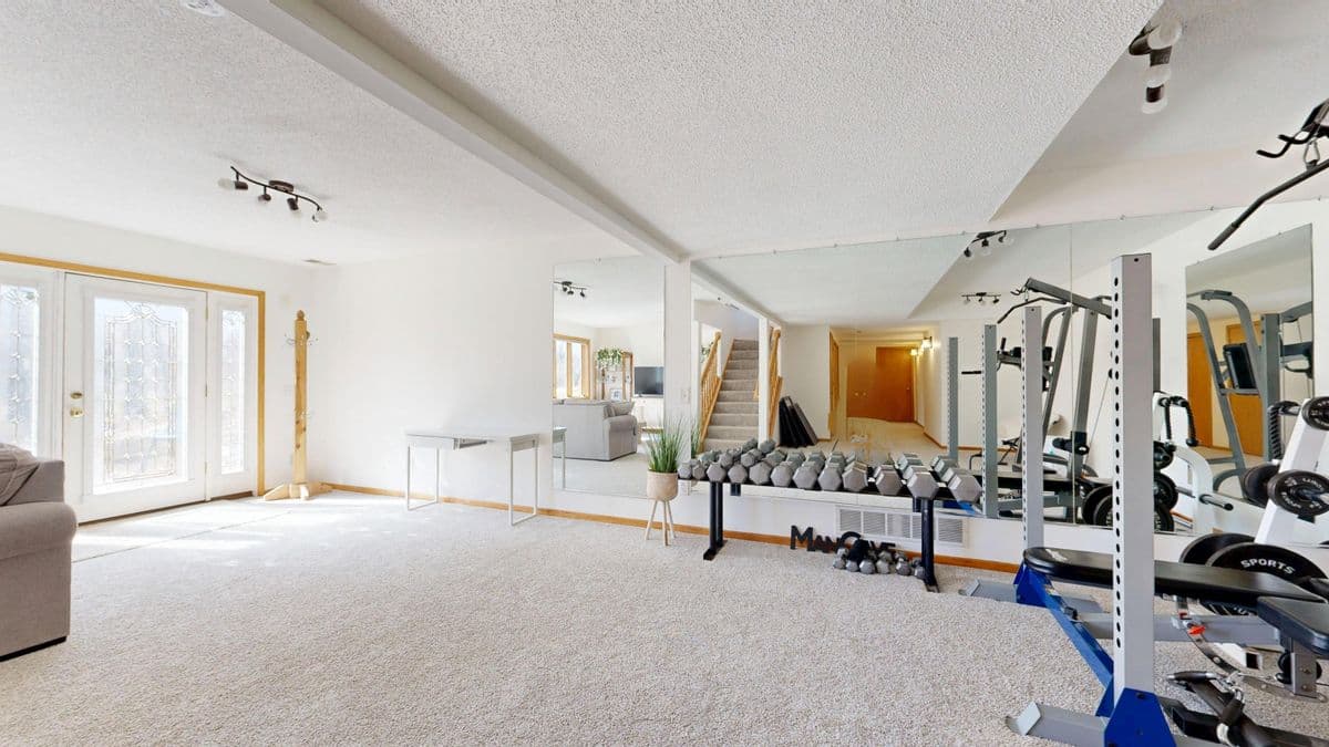 Bright home gym planned with weights, mirrors, and open training space