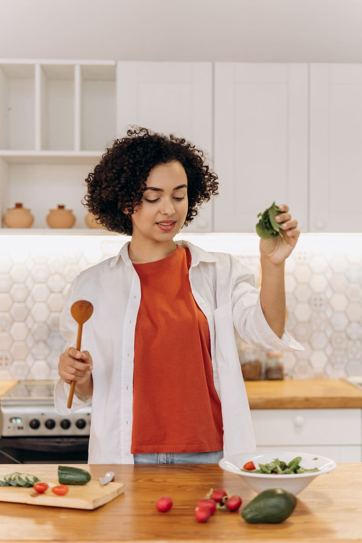 Two women preparing a fresh salad together at home