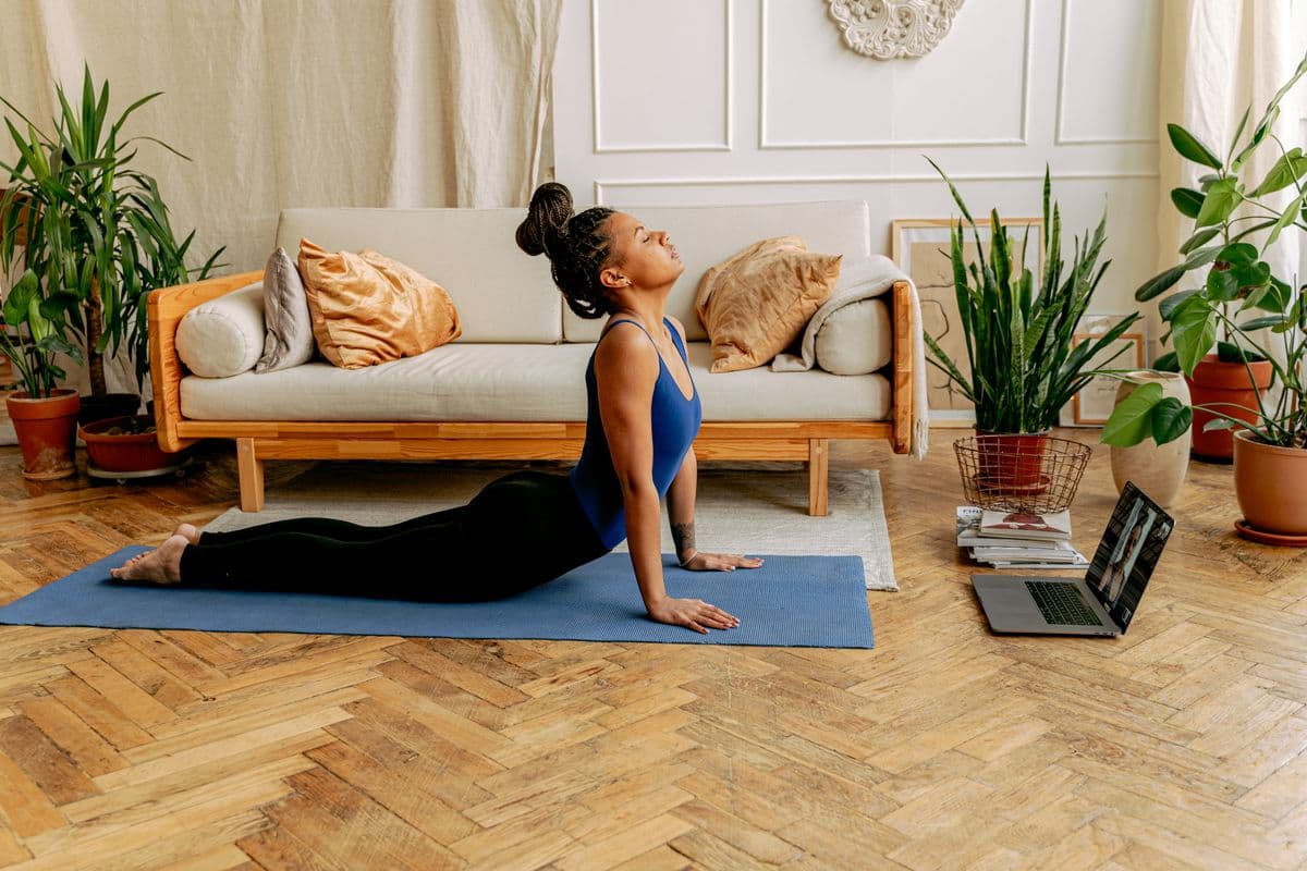 Woman following a guided workout from a laptop at home