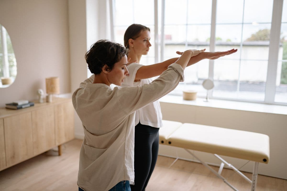 Movement professional helping a client practice a supported exercise