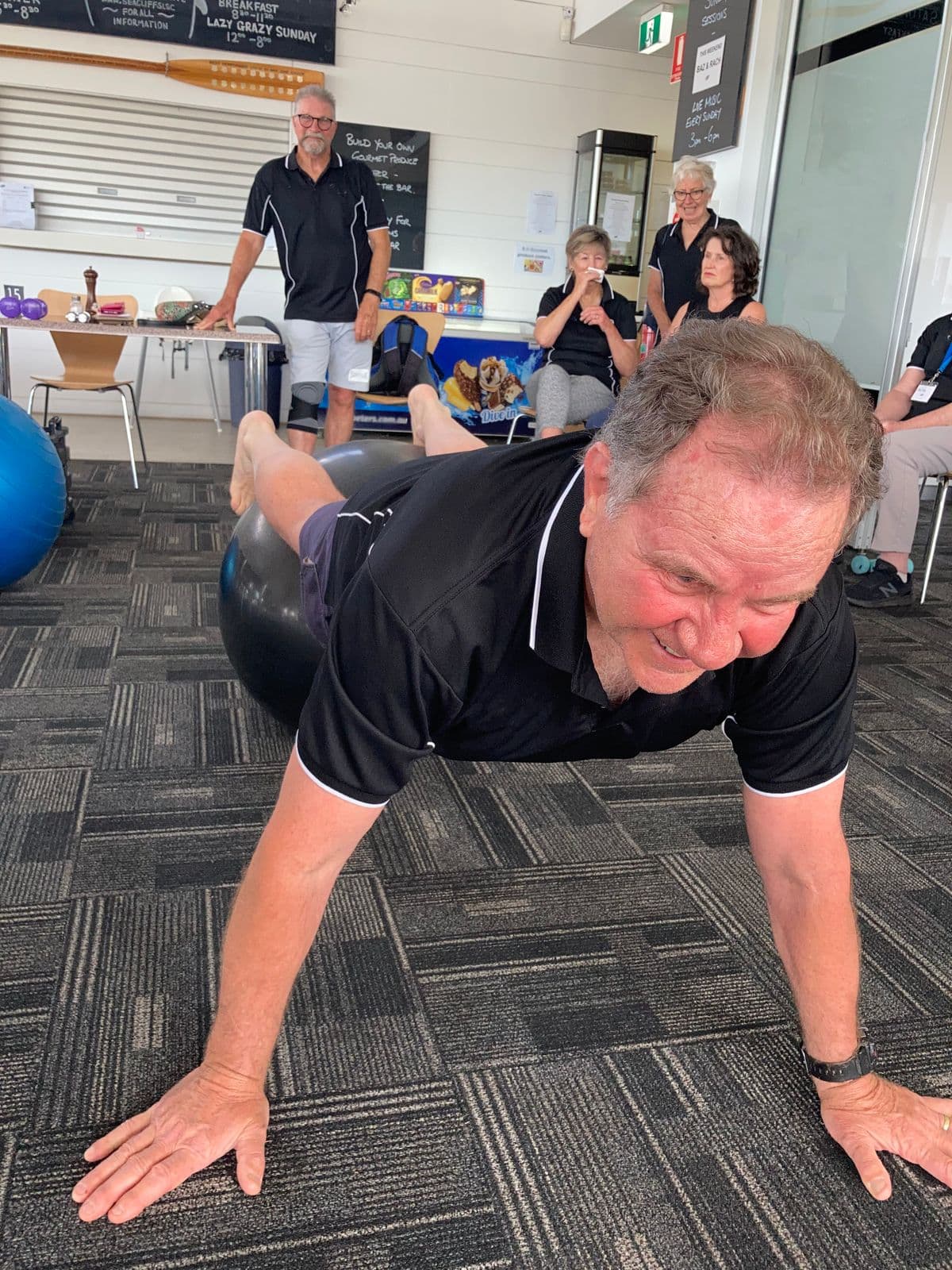 Active older adult practicing a stability exercise with a fitness ball